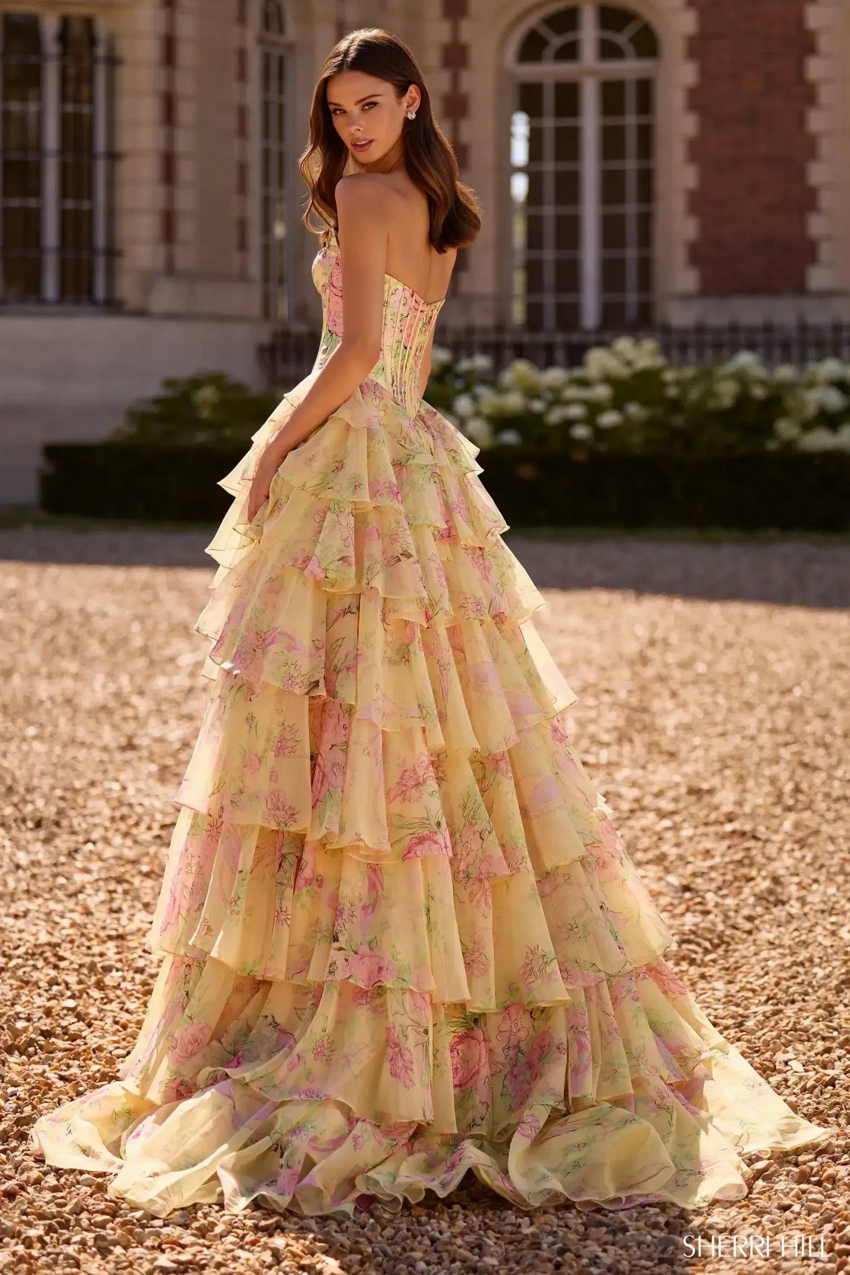 model is wearing a strapless a-line yellow prom dress