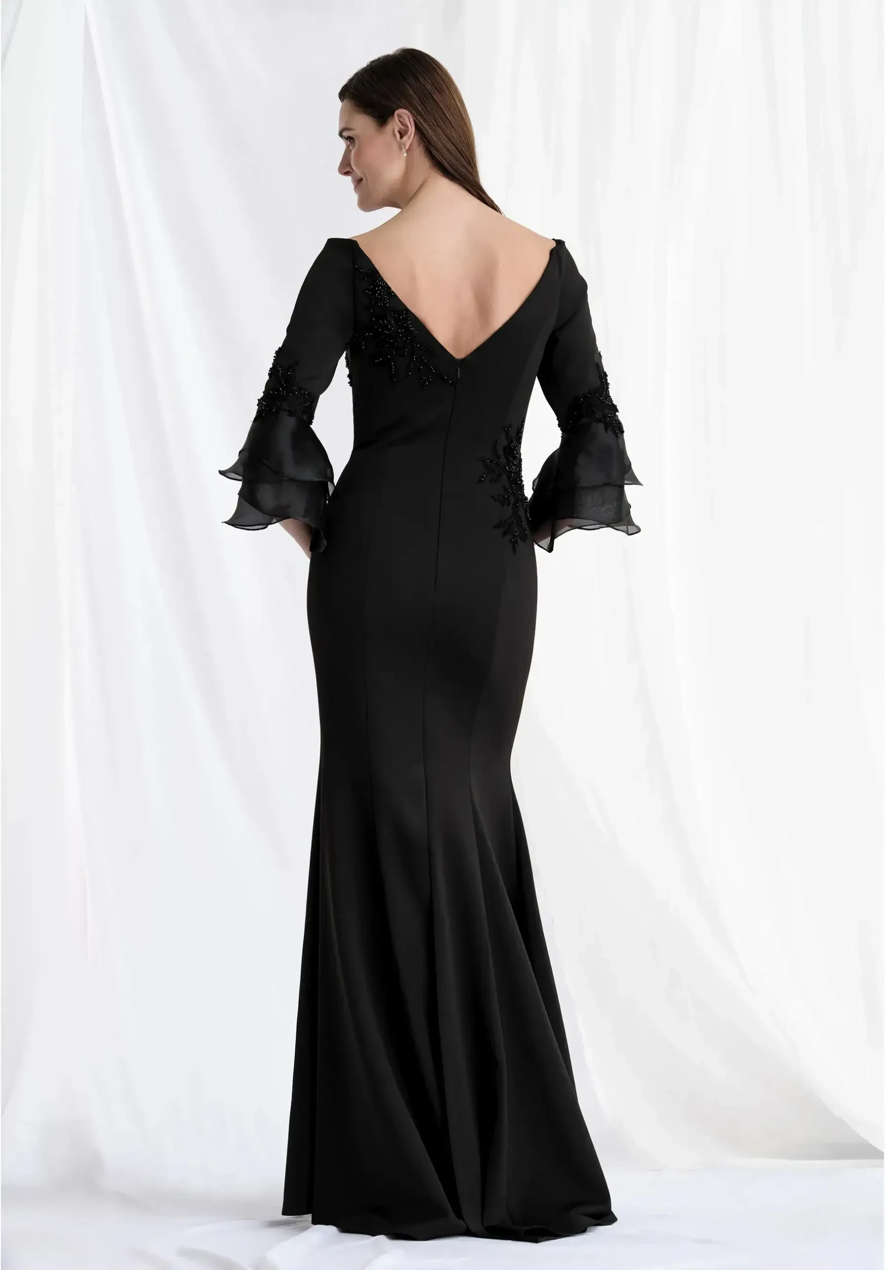 modeli is wearing a bateau neckline black fit and flare evening gown