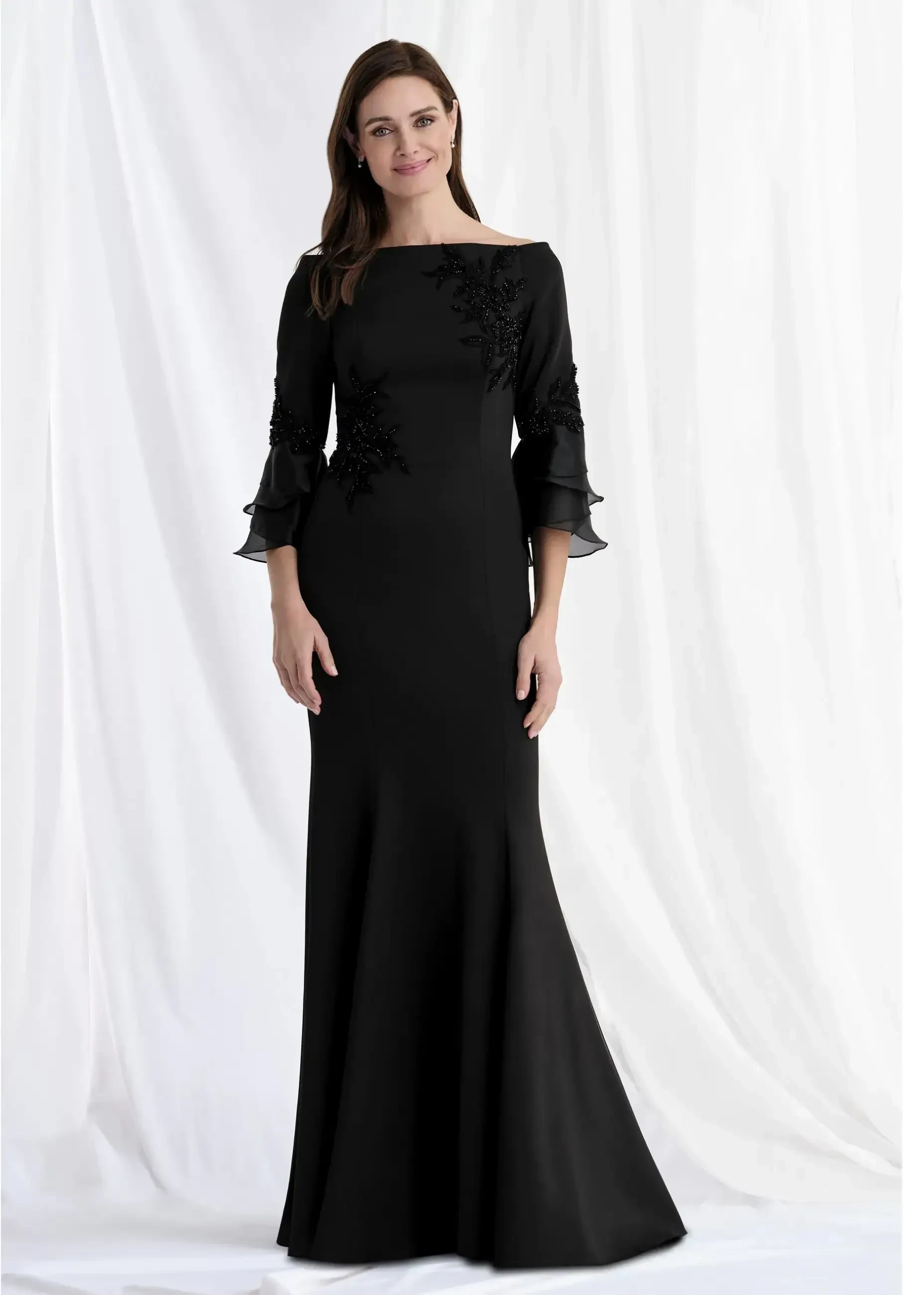modeli is wearing a bateau neckline black fit and flare evening gown
