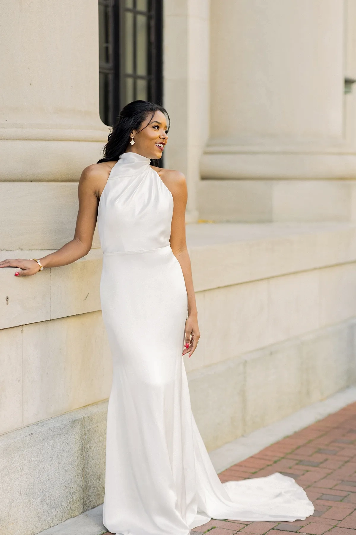 model is wearing a high neck halter sleeveless sheath bridal gown