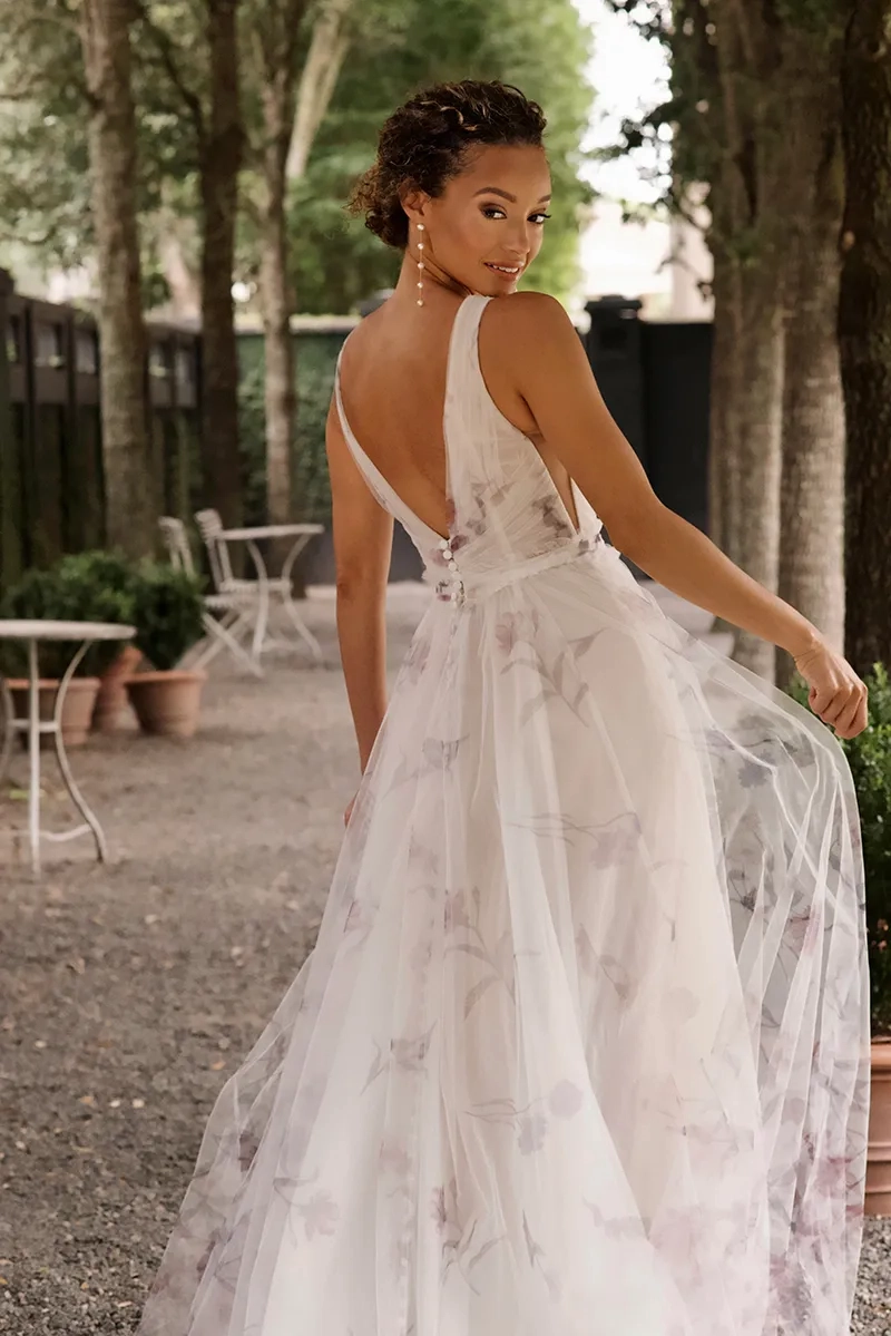 model is wearing a sleeveless floral multicolored bridal gown a-line silhouette
