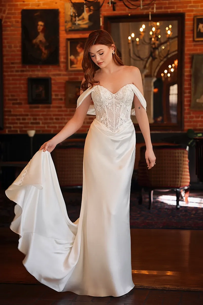 model is wearing an off the shoulder column wedding dress