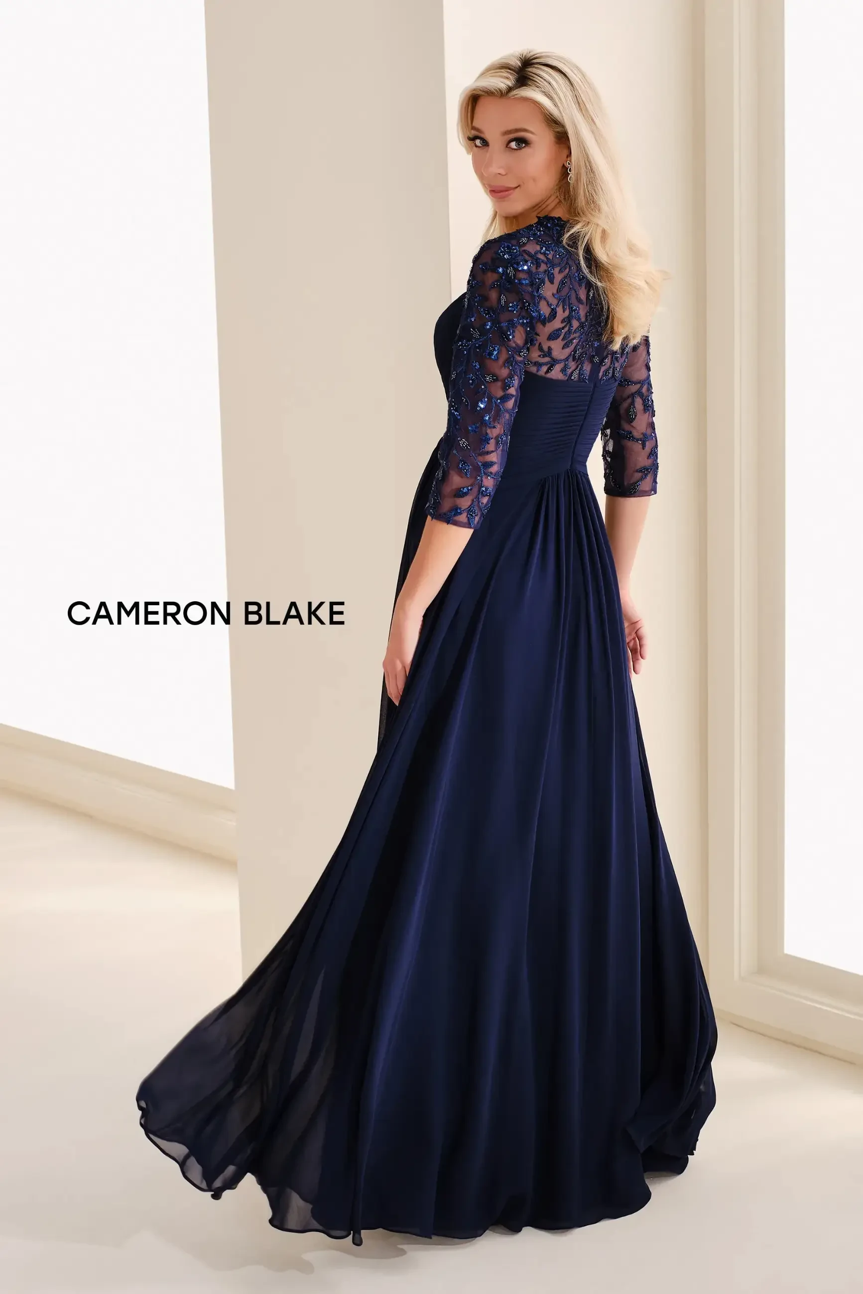 model is wearing a navy blue a-line quarter length sleeve evening gown