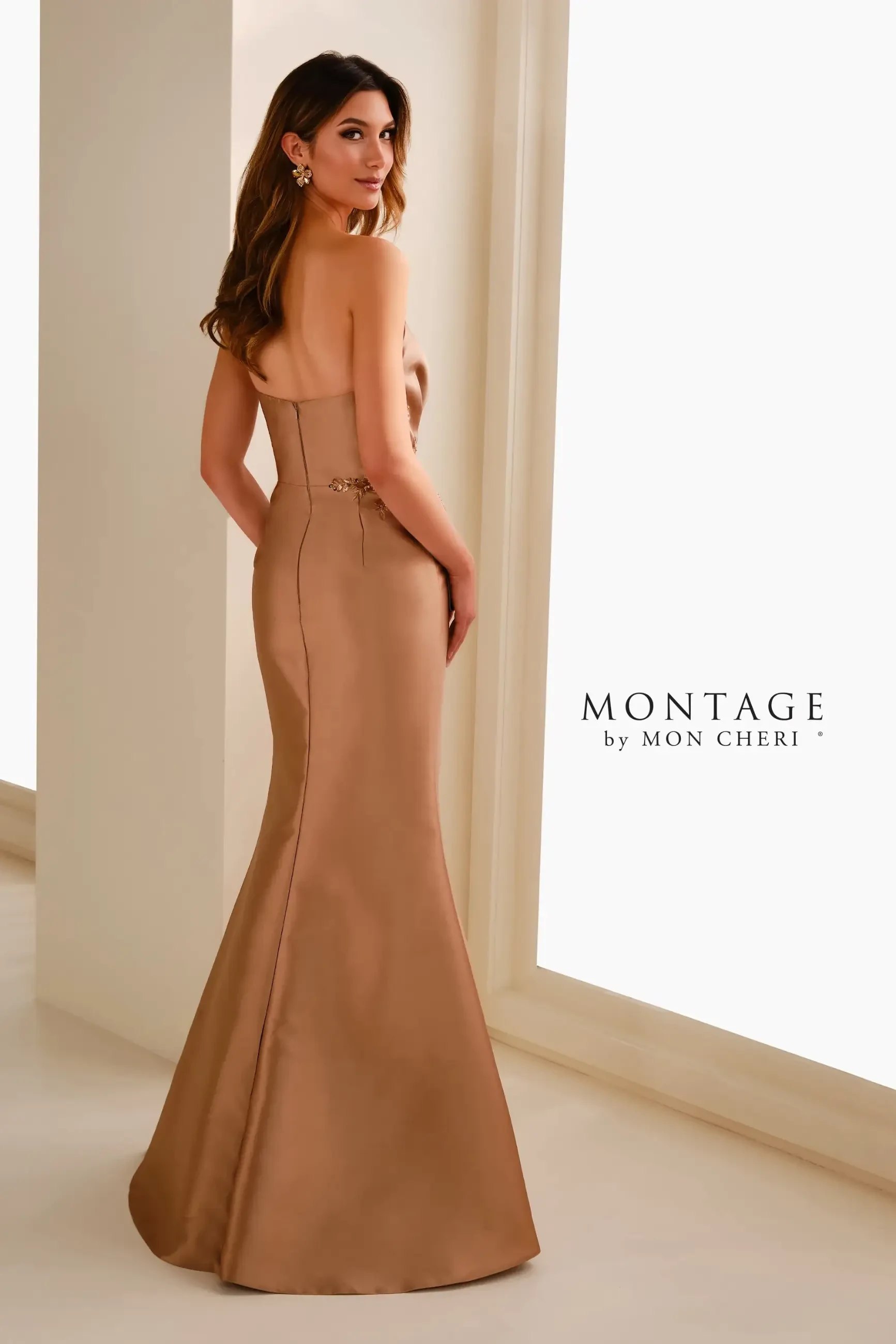 Model is wearing an antique gold Mikado mermaid gown with an asymmetric neckline, beaded lace appliqués, and a matching shawl.