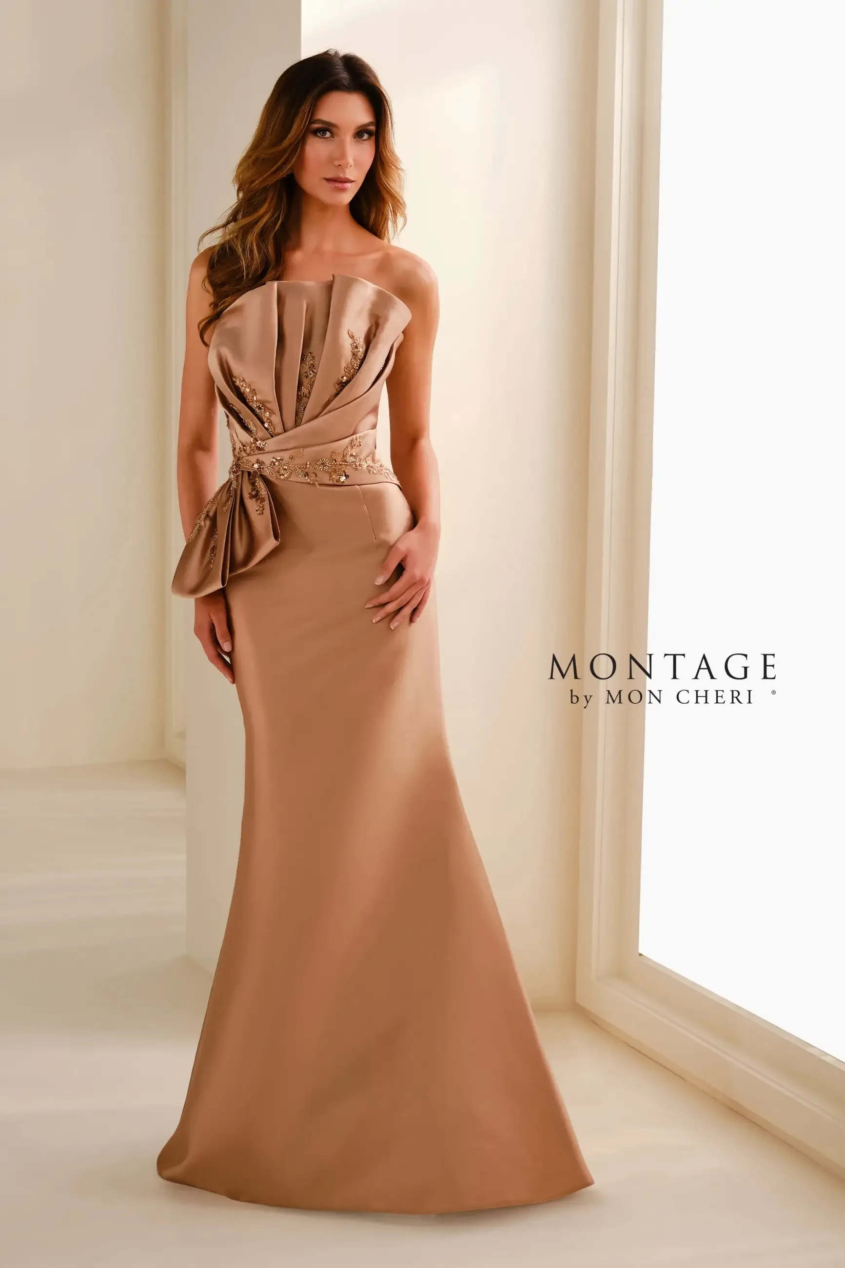 Model is wearing an antique gold Mikado mermaid gown with an asymmetric neckline, beaded lace appliqués, and a matching shawl.